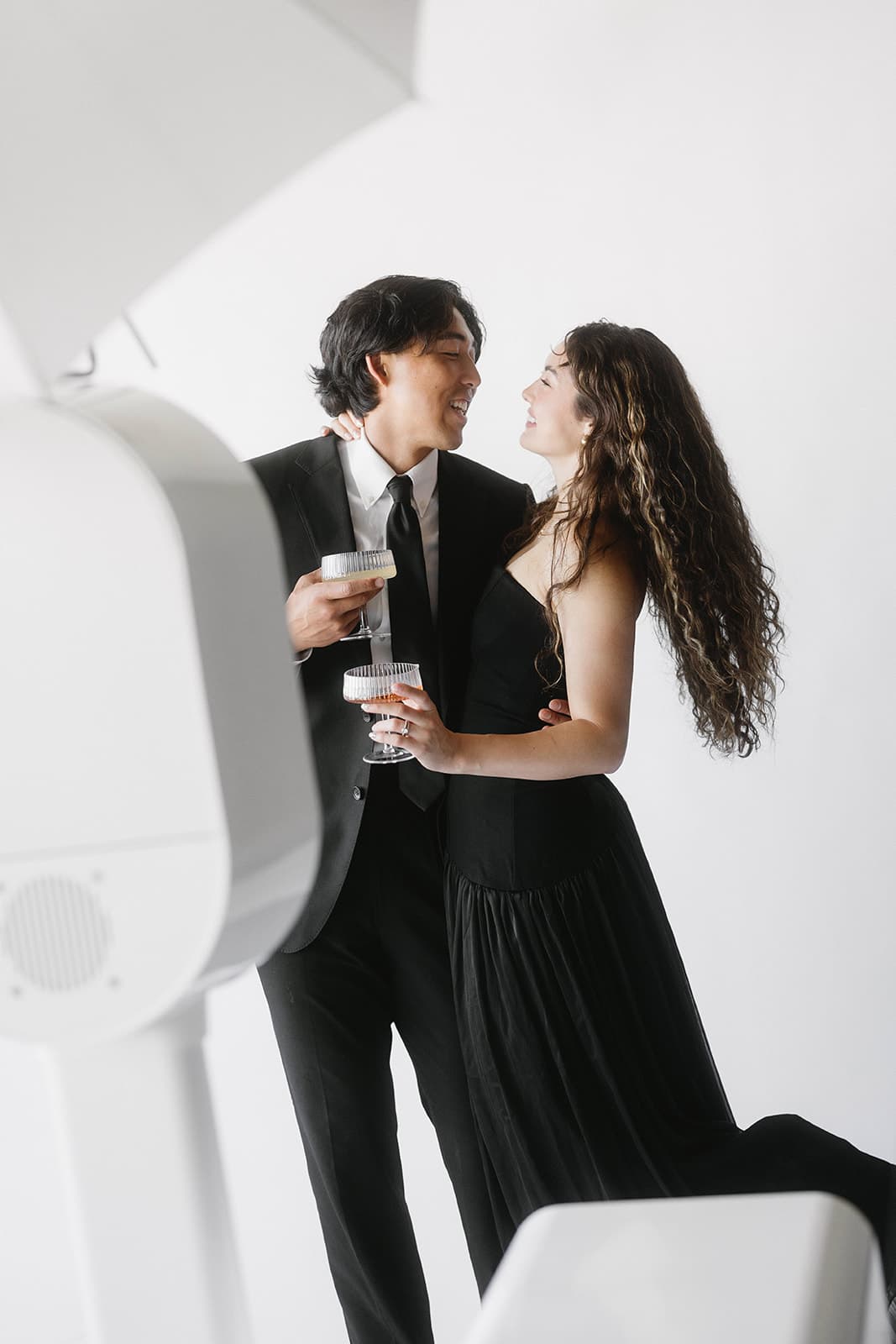 A smiling couple sharing a quiet portrait beside the white Glam Editorial booth