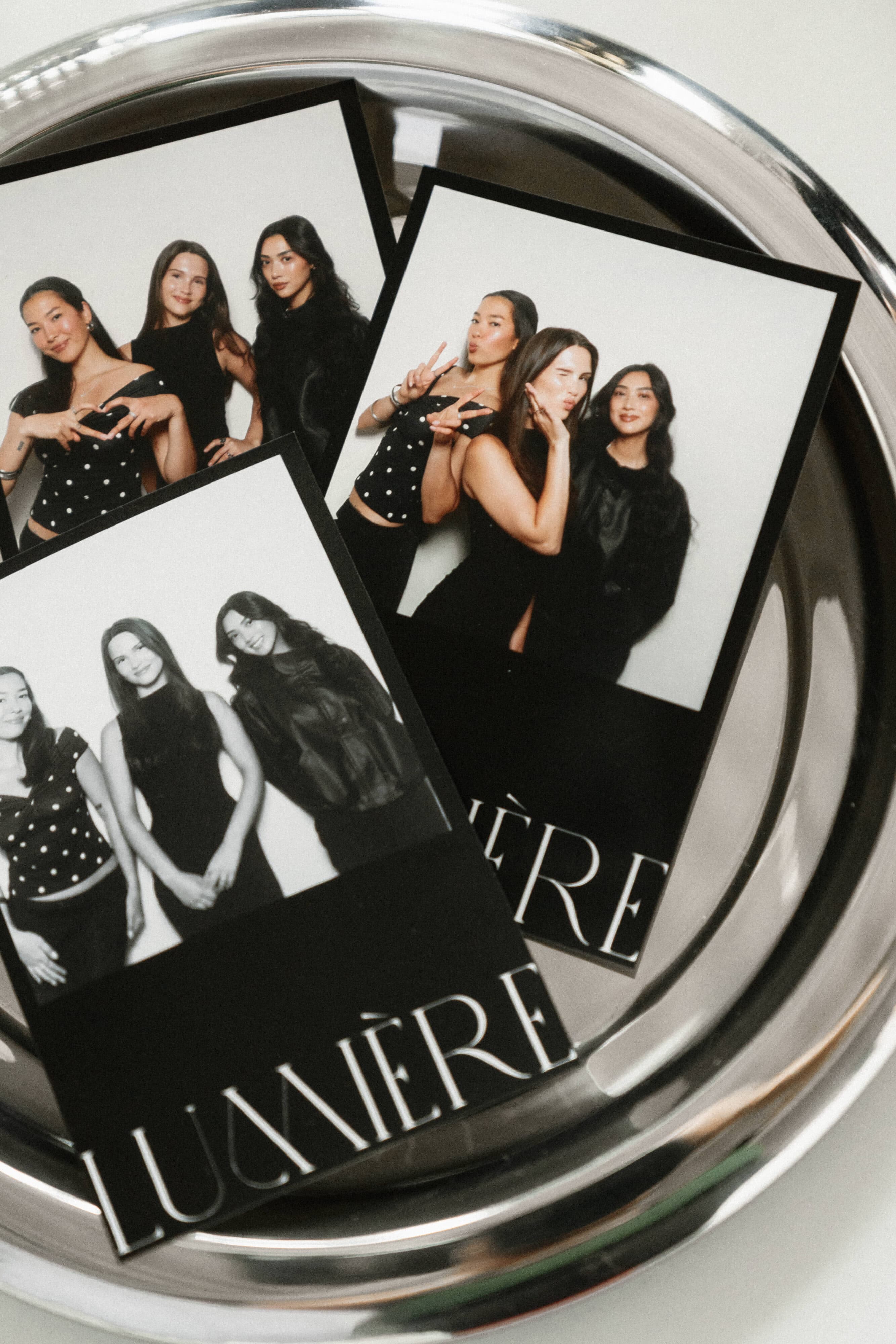 Fresh matte prints laid on a silver tray — the physical keepsakes guests take home