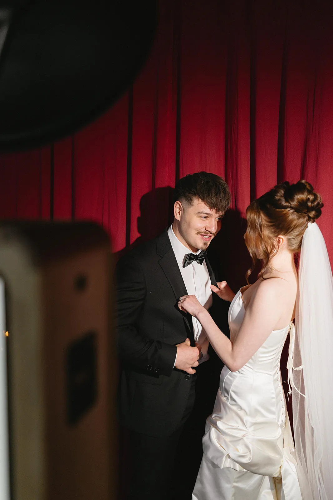 Guests before a deep-red velvet installation, full-colour rendering true to the room